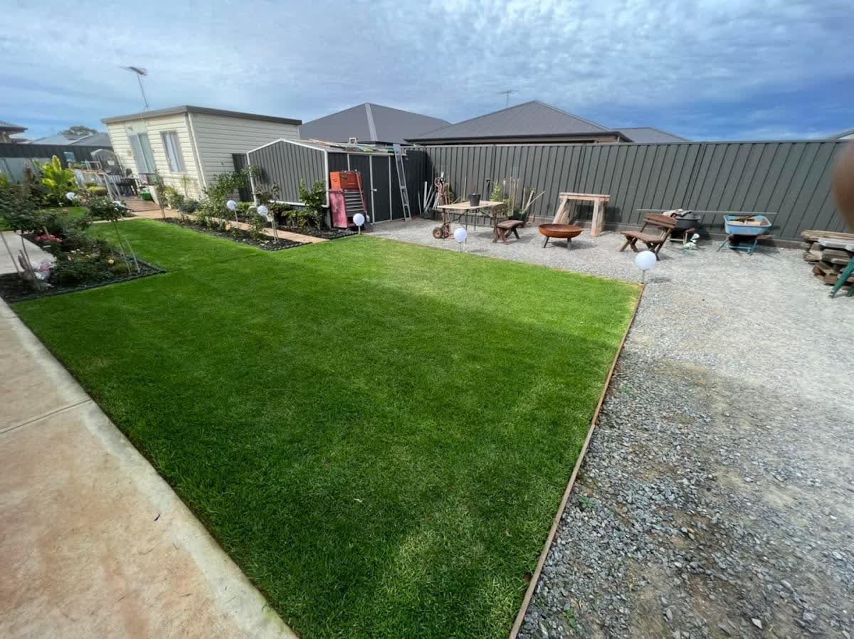A backyard transformed: fresh turf, curved mulch borders and a gravel entertaining space